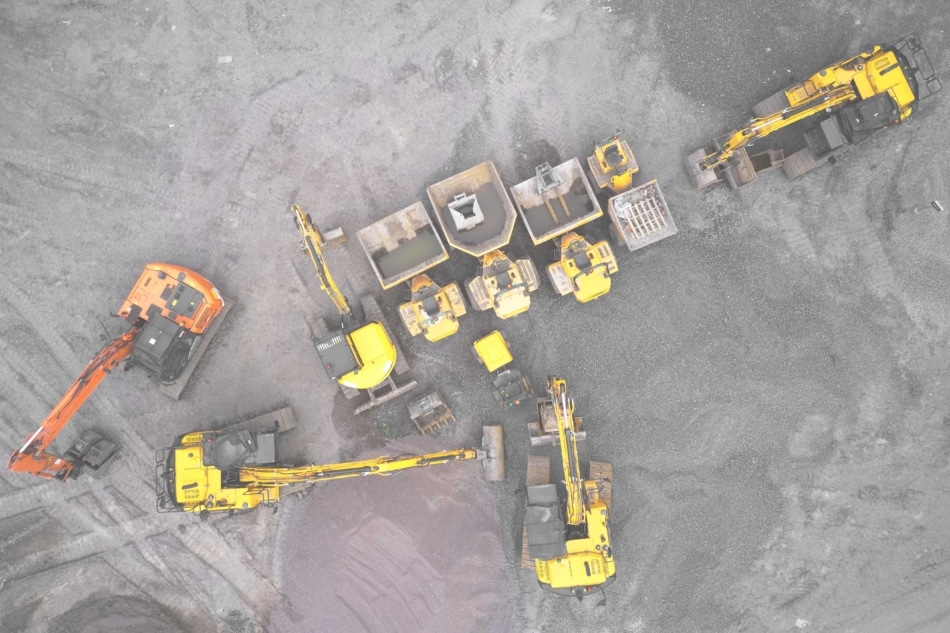 Construction site diggers yellow and orange aerial view from above